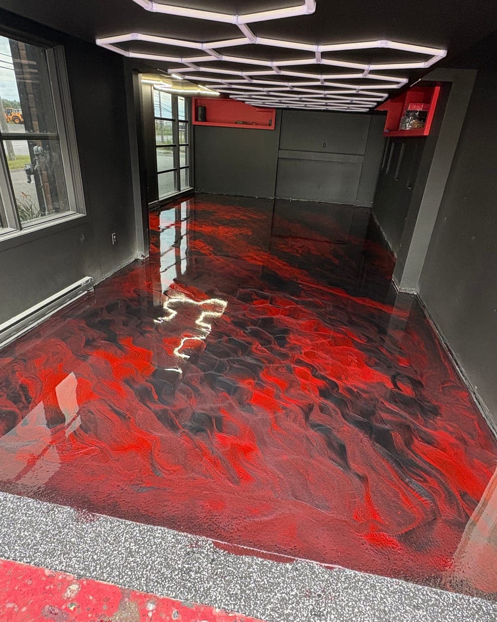 Plancher métallique rouge et noir sous un éclairage hexagonal
